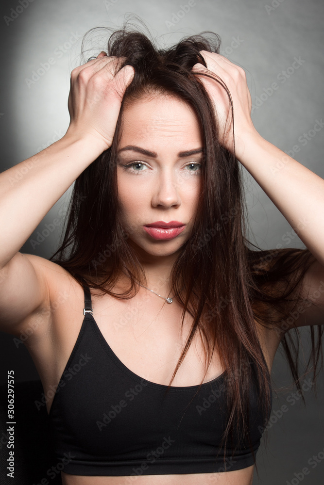 Studio emotional portrait of a brunette girl in dark colors