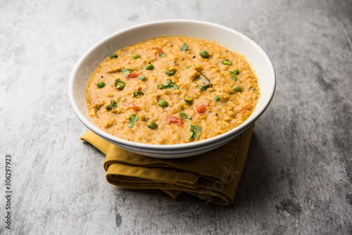 Vegetable masala oats khichadi served in a bowl. selective focus