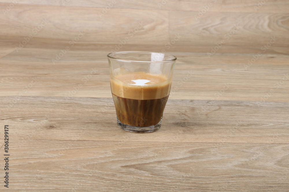 Macchiato Coffee Cup - Coffee in a black cup isolated on a wooden background - Cappuccino Latte Espresso Macchiato Coffee Cup - Coffee in a black cup isolated on a wooden background - Cappuccino Latte Espresso