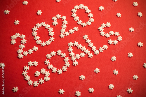 2020 Goals. Creative inscription "2020 Goals" written in white snowflakes on a red background for design. New Year 2020 concept
