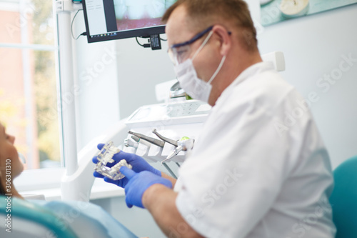 Doctor dentist treats teeth of a beautiful young girl patient.