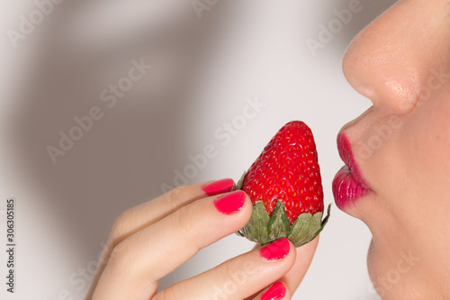 Close up of woman biting a strawberry