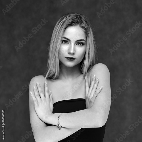 Concept art of beauty, glamor and cosmetics. A large portrait in black and white style of a beautiful model girl with combed hair and bright excellent makeup on a gray background. photo