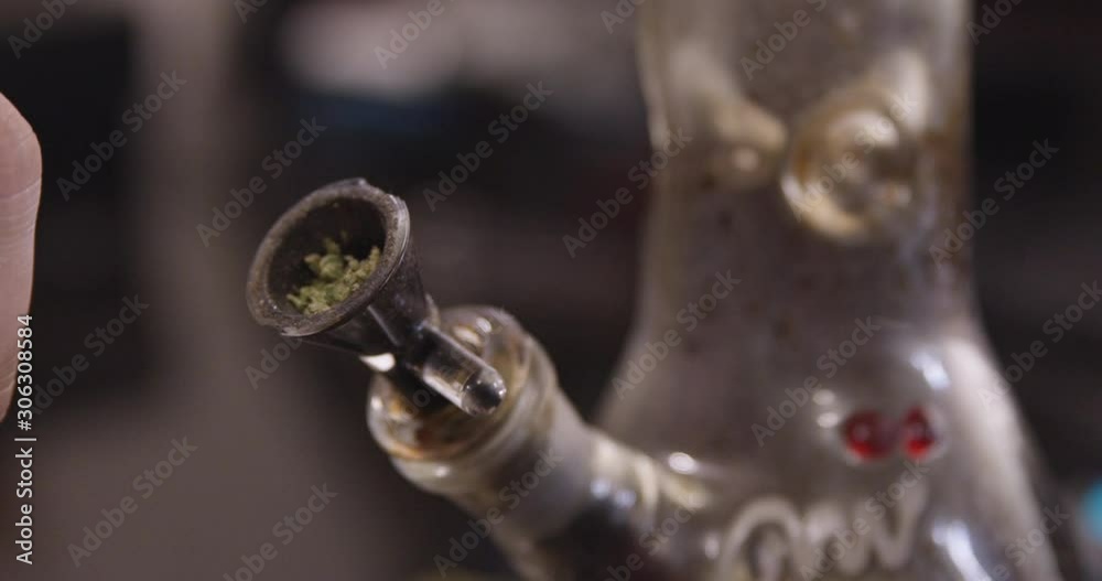 Close Up - Cannabis is packed into a dirty bong bowl - shot on RED Close Up - Cannabis is packed into a dirty bong bowl - shot on RED