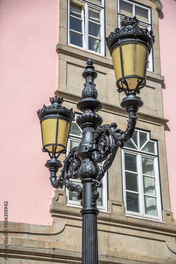 Detailed view of classic retro street lamp post, on metal material, ornamented and with two heads Detailed view of classic retro street lamp post, on metal material, ornamented and with two heads