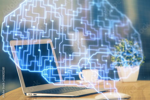 Double exposure of table with computer and brain hologram. Data innovation concept.