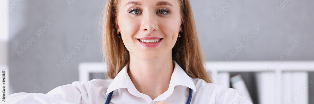 Beautiful smiling doctor hold in arms red heart