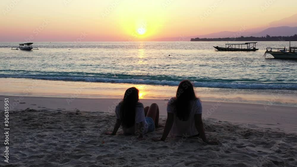Bali, Asian Lesbian Lgbtq Women Couple relaxing on the sandy beach and watching sunset Stock ビデオ | Adobe Stock