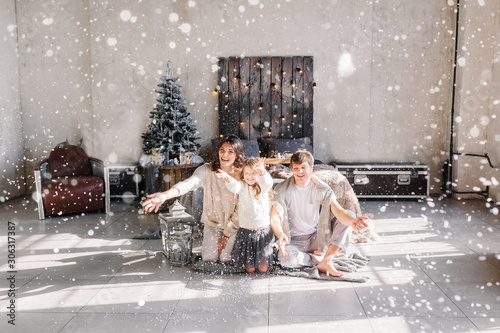 Christmas and new year theme. Parents and children at home playing with fake snow. Laughing joyful & emotions. Christmas 2019.