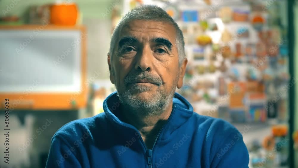 Relaxed serious attractive mature man in his home,looking at camera