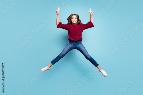 Full length body size photo of cheerful positive preteen showning you double v-sign in brugundy knitted sweater smiling toothily isolated vivid color blue background photo