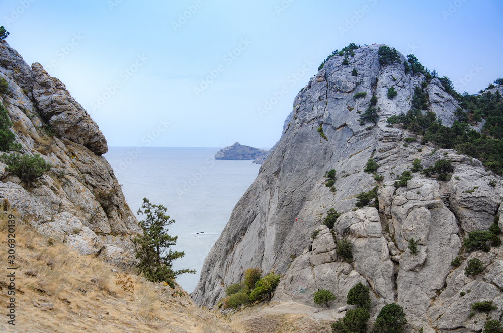 Mountain landscape by the sea. Travel to the sea, rock steep slope and mountain vegetation.
