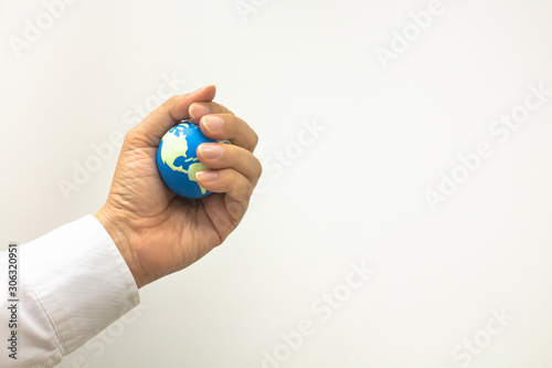 Global business concept, Closeup of businessman hand holding mini world ball in his fist on white background and copy space for text.