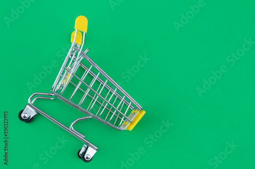 Yellow shopping cart or trolley on yellow background with room for text