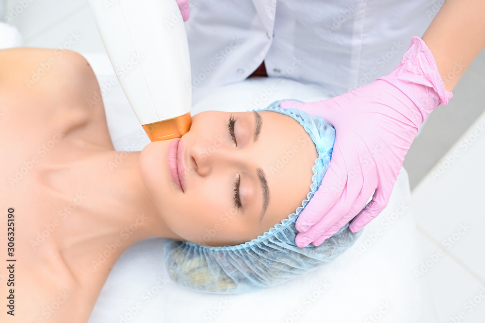 Naklejka premium Anti-aging procedures. Skin care concept. Woman receiving facial beauty treatment, removing pigmentation at cosmetic clinic. Intense pulsed light therapy. IPL. Rejuvenation, photo facial therapy.