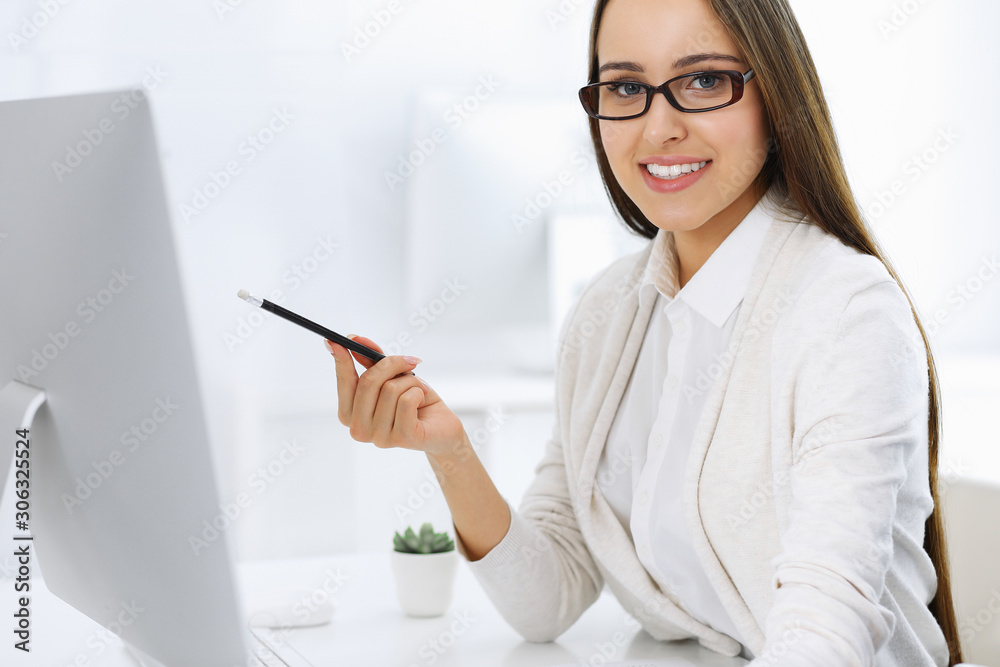 Business woman and man sitting and working with computer and calculator in office. Bookkeeper or accountant checking balance or making finance report. Tax and audit concepts Business woman and man sitting and working with computer and calculator in office. Bookkeeper or accountant checking balance or making finance report. Tax and audit concepts