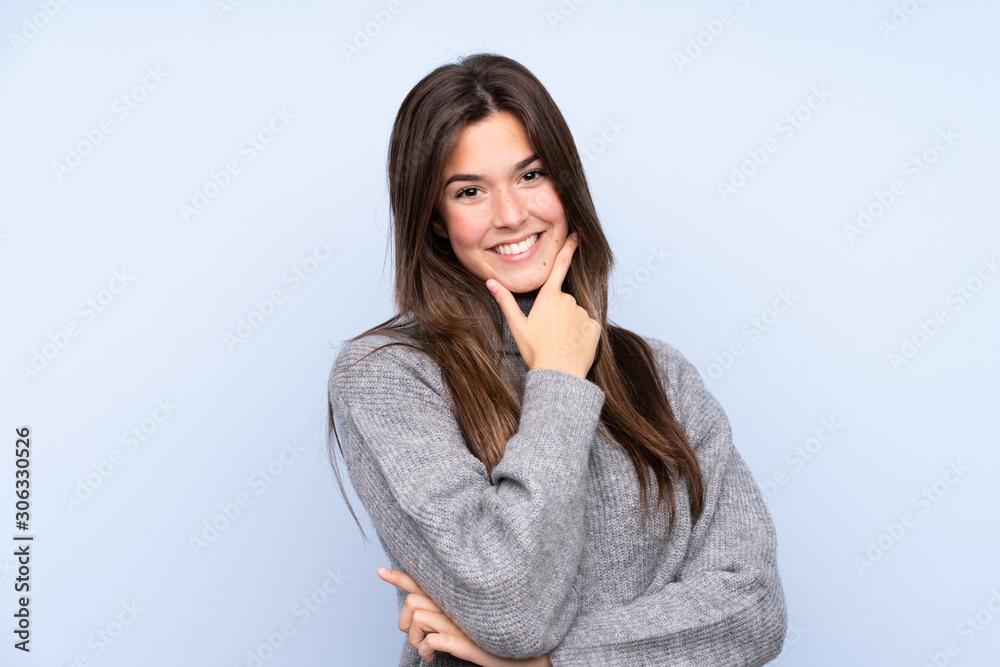 Teenager Brazilian girl over isolated blue background smiling Teenager Brazilian girl over isolated blue background smiling