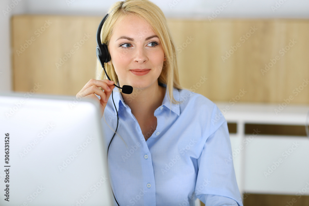 Call center. Blonde business woman sitting in headset at customer service office. Concept of telesales business or home office occupation Call center. Blonde business woman sitting in headset at customer service office. Concept of telesales business or home office occupation