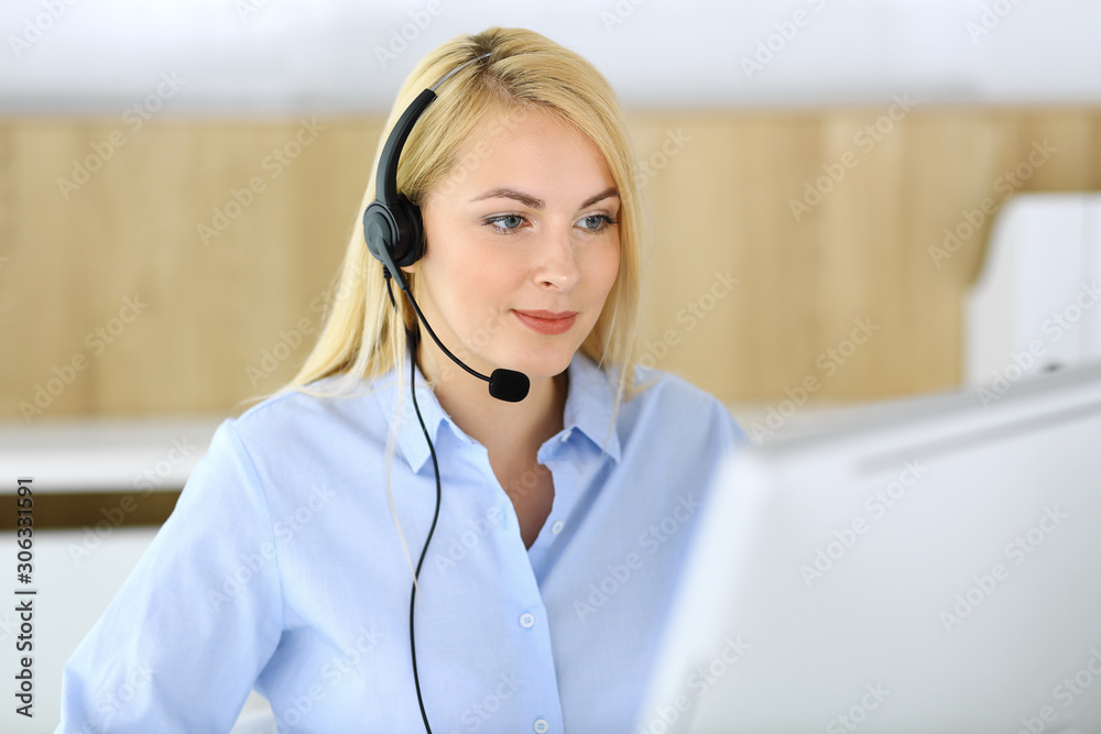 Call center. Blonde business woman sitting in headset at customer service office. Concept of telesales business or home office occupation Call center. Blonde business woman sitting in headset at customer service office. Concept of telesales business or home office occupation