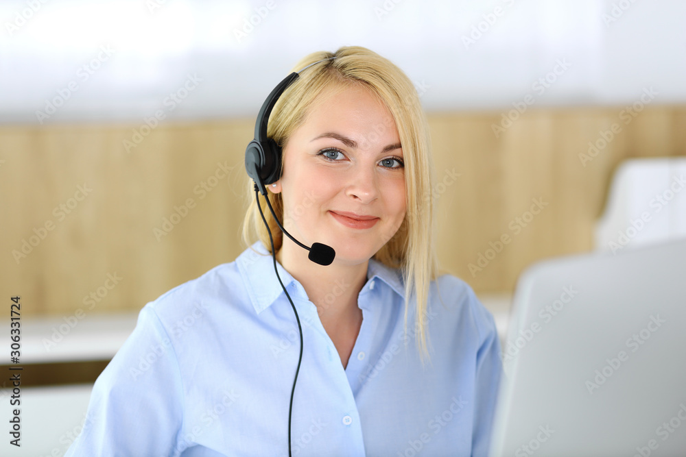 Call center. Blonde business woman sitting in headset at customer service office. Concept of telesales business or home office occupation Call center. Blonde business woman sitting in headset at customer service office. Concept of telesales business or home office occupation