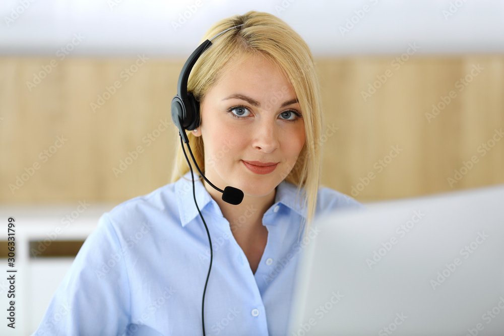 Call center. Blonde business woman sitting in headset at customer service office. Concept of telesales business or home office occupation Call center. Blonde business woman sitting in headset at customer service office. Concept of telesales business or home office occupation
