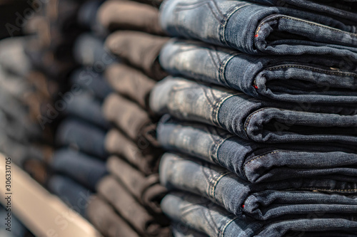 Closeup shot of stack of folded jeans in fashion store.