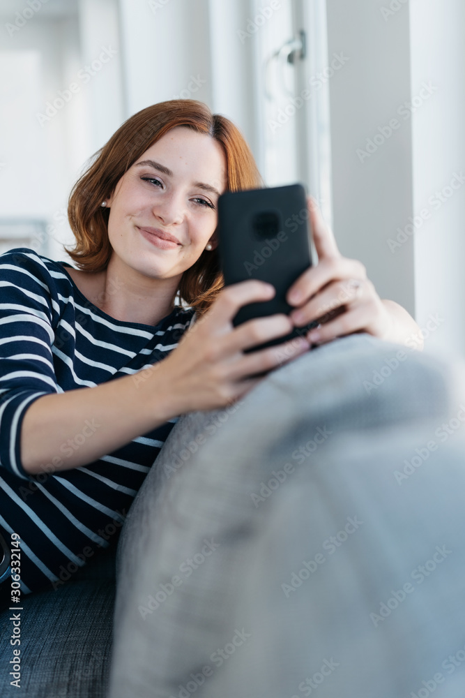 Young woman reading a text message on a mobile Young woman reading a text message on a mobile