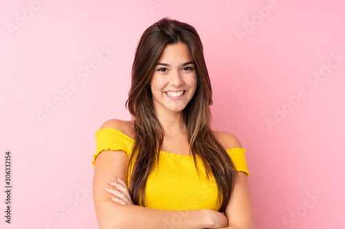 Teenager Brazilian girl over isolated pink background keeping the arms crossed in frontal position