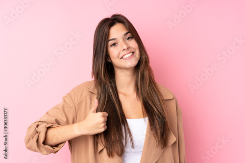 Teenager Brazilian girl over isolated pink background giving a thumbs up gesture