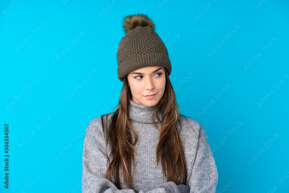 Teenager girl with winter hat over isolated blue background thinking an idea Teenager girl with winter hat over isolated blue background thinking an idea