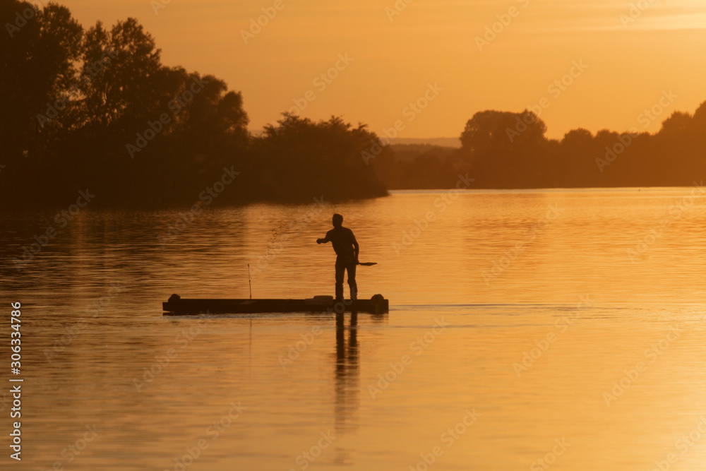 Silhouette of the fisherman on the boat during sunset on the Soderica Lake, Croatia