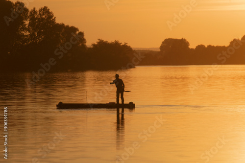 Silhouette of the fisherman on the boat during sunset on the Soderica Lake  Croatia