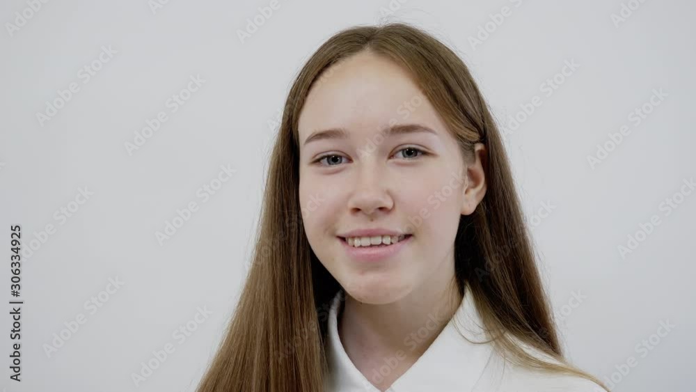 Portrait of Happy Teen Girl Smiling on White Background. Cheerful Casual Young Woman with Funny Face Looking at Camera Closeup. Sincere Positive Emotions. Expressive Look of a Dark-Haired Teenager. Portrait of Happy Teen Girl Smiling on White Background. Cheerful Casual Young Woman with Funny Face Looking at Camera Closeup. Sincere Positive Emotions. Expressive Look of a Dark-Haired Teenager.