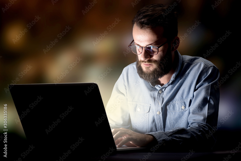 Young handsome businessman working late at night in the office Young handsome businessman working late at night in the office