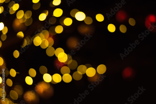 Christmas lights with highlights sparkles on a dark background. Out of focus, blues. Festive atmosphere of lights in the night.
