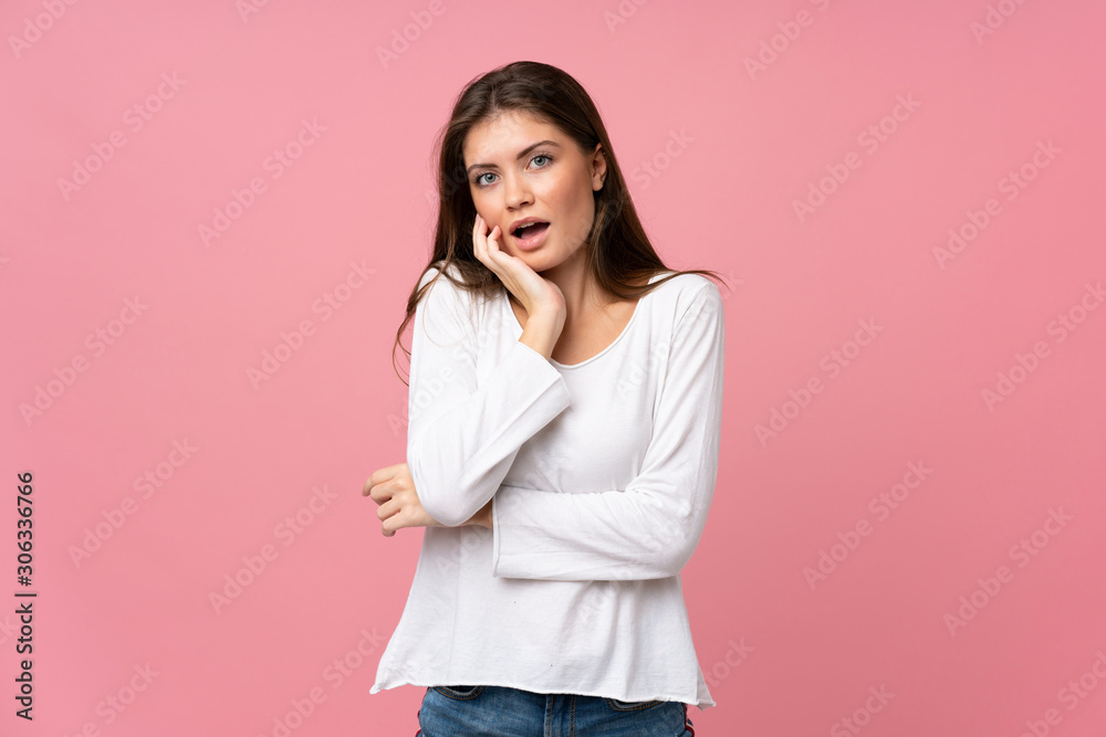 Young woman over isolated pink background surprised and shocked while looking right Young woman over isolated pink background surprised and shocked while looking right