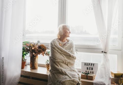 Obraz na płótnie Senior woman looking to window and enjoying Christmas holiday w salonie