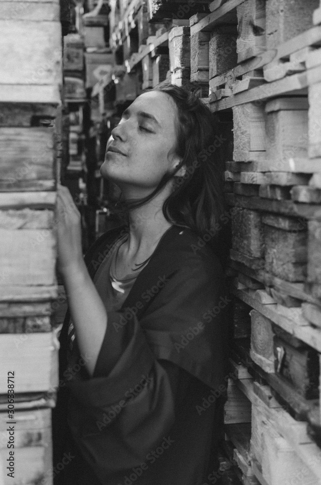 Black and white shot of Woman in red posing near wooden pallets. Eco concept Black and white shot of Woman in red posing near wooden pallets. Eco concept