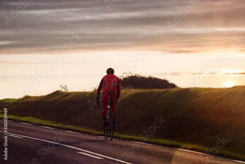 cyclist climbing a slope at sunset © Image'in