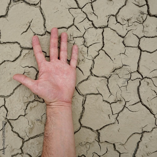 man hand on the dry ground, global warming
