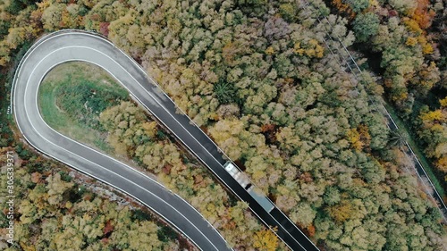 Winding road through a forest, truck taking a sharp turn