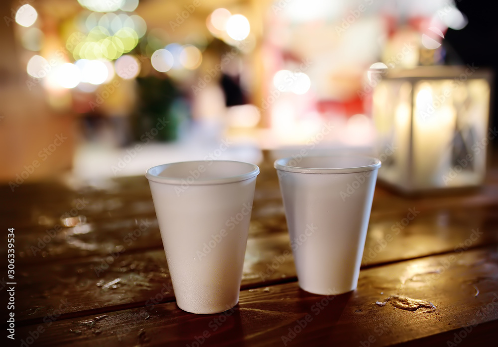 Pair of disposable cups on a wooden table on Christmas street market. Xmas holidays on famous fair in Tallinn, Estonia. Pair of disposable cups on a wooden table on Christmas street market. Xmas holidays on famous fair in Tallinn, Estonia.