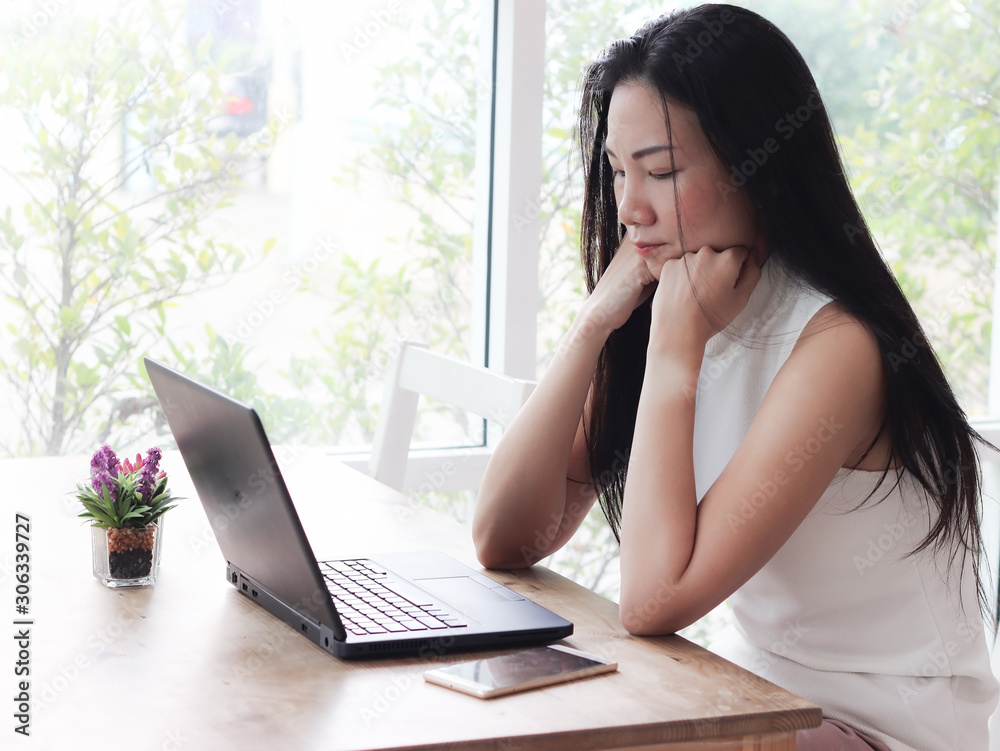 Beautiful asian woman sitting alone in coffee shop with computer on table , Beautiful asian woman sitting alone in coffee shop with computer on table ,