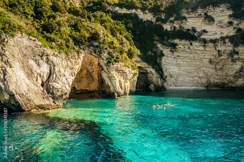 Two kayaks approaching huge cave in the cliffs