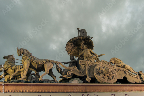 A statue of a chariot on the top of a gate in Parmarth photo