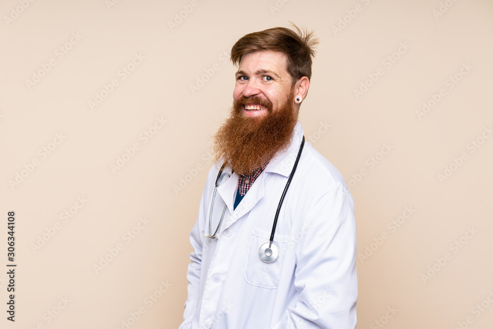 Redhead man with long beard over isolated background with doctor gown Redhead man with long beard over isolated background with doctor gown