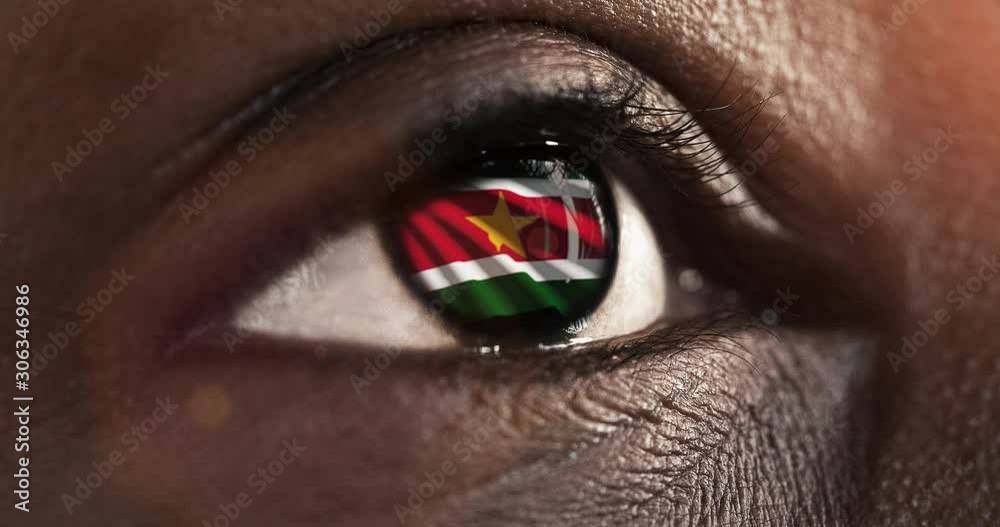 Woman black eye in close up with the flag of Suriname in iris with wind motion. video concept