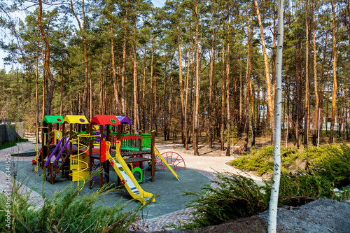 The kid's playground is surrounded by trees