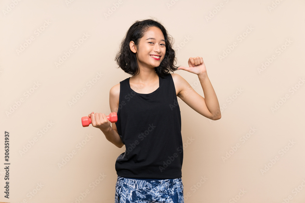 Young Asian girl making weightlifting over isolated background proud and self-satisfied