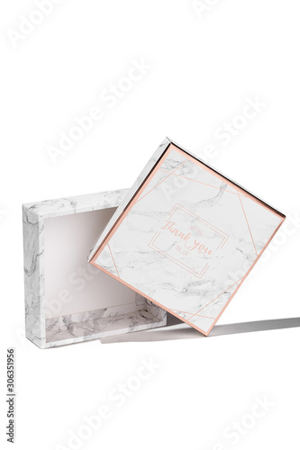 Subject shot of a gift box with a white bottom and a lid decorated with grayish mottled print with goldish lines and and a pleasant text: "Thank you. Join us. Good time to meet you."